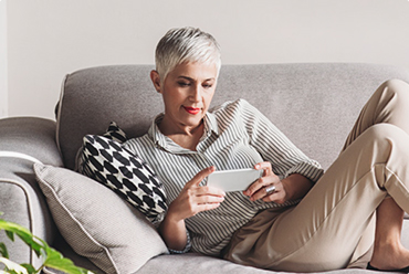 Woman lying on couch with phone